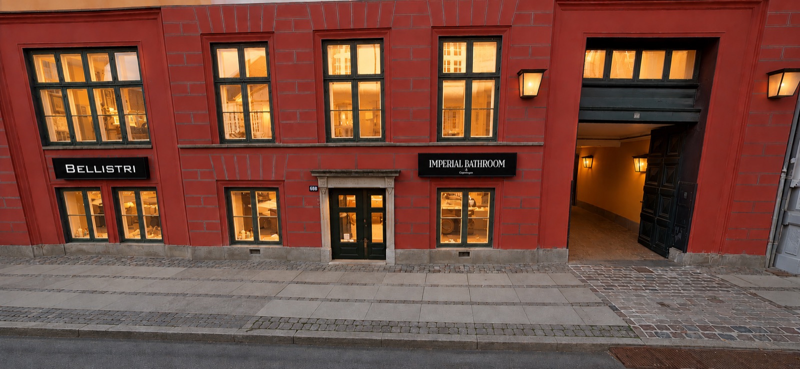 Bellistris showroomfasad på en rödtegelgata i Köpenhamn, upplyst i skymningen